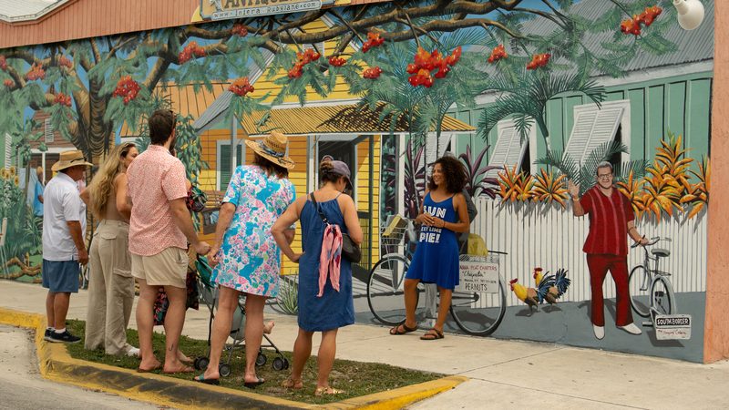 Guide leading a tour group in front of the Bahama Village mural on Petronia Street in Key West