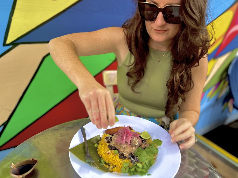 Guest about to dig into a Cuban plate of yellow rice, black beans and pickled red onion at Kaya's Backyard in Key West