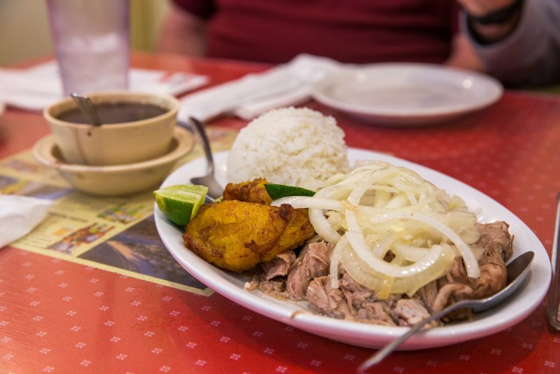Plate of Cuban roast pork with white rice, black bean soup and a fried plantain at El Siboney in Key West