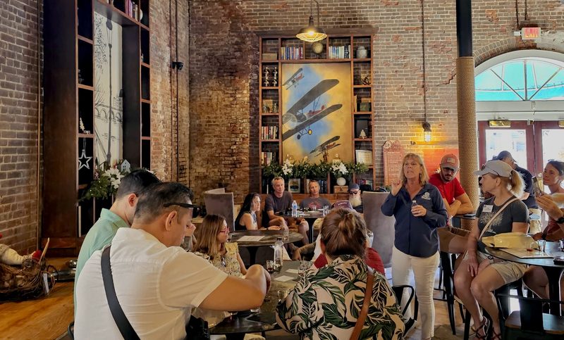 Key West Food Tours guide talking to a seated tour group during the rum tasting at the Hemingway Distillery's Social Club