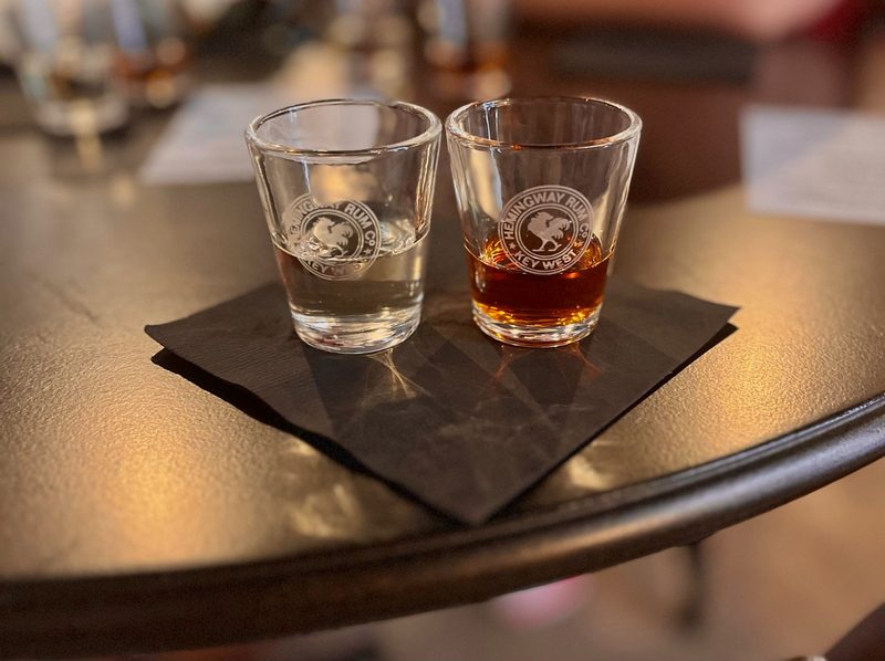 Two Hemingway Rum Company tasting glasses with blonde and dark Pilar rum, on a bar table at the Key West distillery