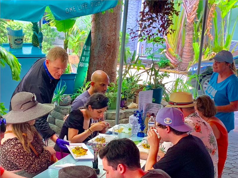 Tour guests tasting a plated course together on the patio at Kaya's Backyard in Key West