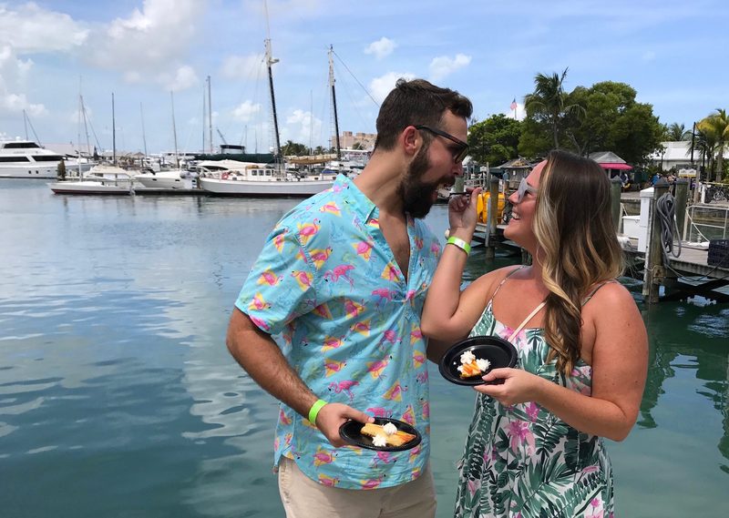 Couple sharing a bite of Key lime pie on the boardwalk at the Key West Historic Seaport marina