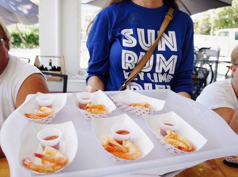 Server carrying a tray of peel-and-eat Key West pink shrimp from Eaton Street Seafood Market