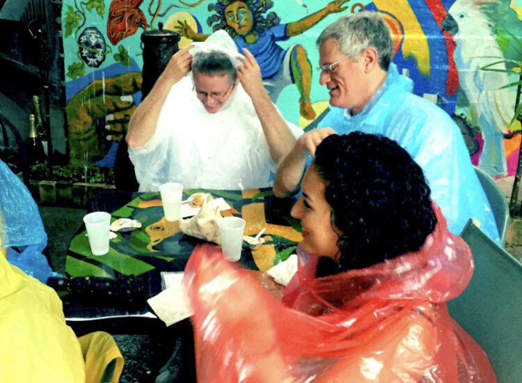 Guests wearing ponchos smiling on a rainy food tour in Key West