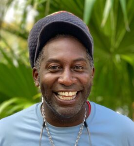 a man wearing a hat and smiling at the camera