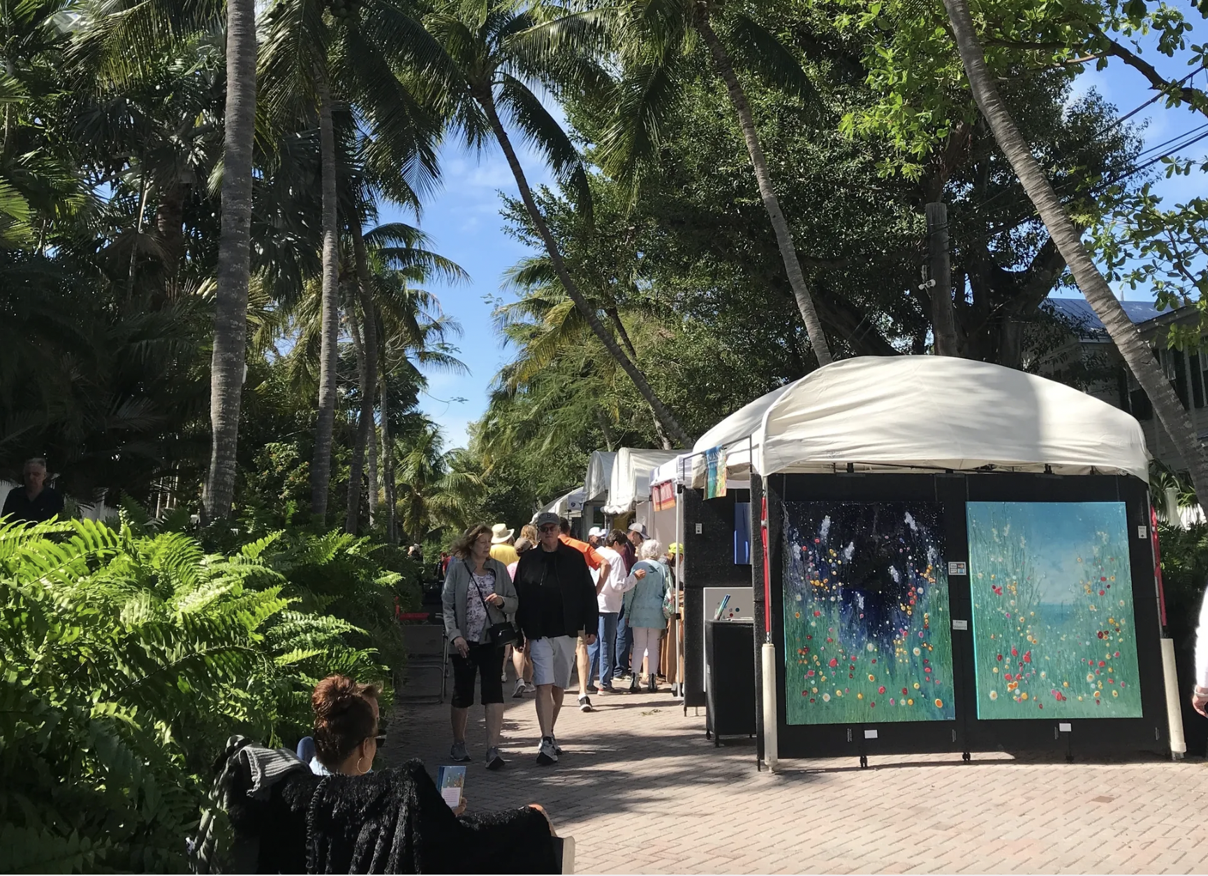 Customers walking through an outdoor market.